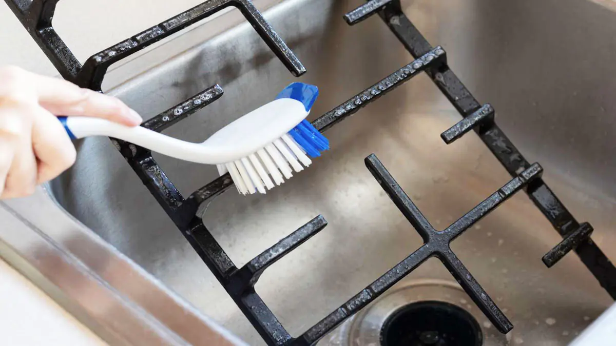 Gie&szlig;en Sie 1 Tasse kochendes Wasser in den Rost und tauchen Sie den verschmutzten Kochfeldrost hinein.